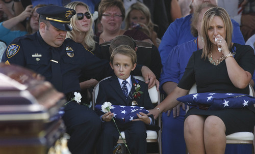 Leah Hogsten | The Salt Lake Tribune
l-r Draper Sgt. Pat Evans, Ben Johnson, 6, and Shante Johnson at the gravesite service for Shante's husband, Draper Police Sgt. Derek Johnson.  Evans and Johnson were best friends throughout their childhood and joined the Draper force together. Johnson was laid to rest at Larkin Sunset Mortuary, September 6, 2013. Sgt. Johnson was shot by a transient after the 32-year-old officer pulled up in his patrol car to investigate the man's vehicle. The suspect, Timothy Troy Walker, then shot his passenger, Traci Vaillancourt, and himself.