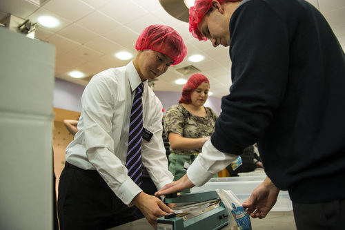 Chris Detrick  |  The Salt Lake Tribune
Mormon missionaries Insu Kim and Joel Moore work at preparing meals at the Missionary Training Center in Provo Thursday November 28, 2013. The 1,800 missionaries spent Thanksgiving by preparing 350,000 meals for hungry Utah children. The packages of nutritious, nonperishable food will be provided to Utah schools where they are sent home with children in need.