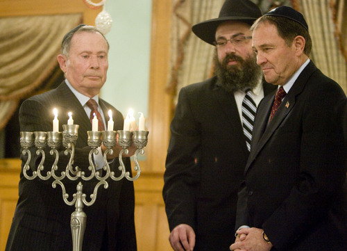 Keith Johnson | The Salt Lake Tribune

Utah Governor Gary Herbert, right, and Rabbi Benny Zippel of Chabad Lubavitch of Utah watch as former U.S. Ambassador John Price, whose family fled Nazi Germany when he was 5 years old, lights the menorh during the menorah-lighting ceremony at the Governor's Mansion, December 2, 2013 in Salt Lake City. Community and religious leaders representing many faiths were present for the event.