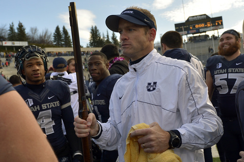 Chris Detrick  |  The Salt Lake Tribune
Utah State Aggies head coach Matt Wells holds the rifle after the game at Merlin Olsen Field at Romney Stadium Saturday November 30, 2013.  Utah State defeated Wyoming 35-7. The Aggies will visit Fresno State in the title game next Saturday to complete their first season of MW competition.