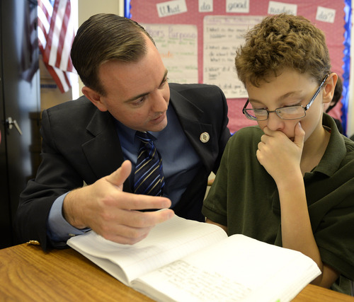 Rick Egan  | The Salt Lake Tribune 

West Valley City Mayor Mike Winder helps Carson Hoffman, a sixth-grader at Endeavor Hall Charter School, write a letter asking President Obama to visit Utah, Thursday, Dec. 5, 2013.