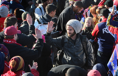 Scott Sommerdorf   |  The Salt Lake Tribune
RSL fans give midfielder Kyle Beckerman high fives as he and other Real Salt Lake players and coaches as they make their way through a sea of fans after arriving in Salt Lake at the TAC Air sports terminal, Sunday December 8, 2013.