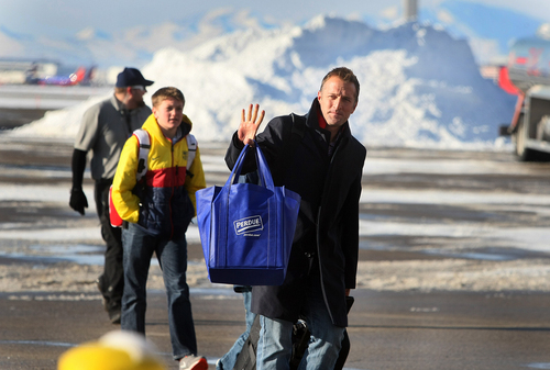 Scott Sommerdorf   |  The Salt Lake Tribune
Real Salt Lake head coach Jason Kreis waves to fans who had braved the below-freezing temperatures to wait for the team to return. RSL players and coaches arrive in Salt Lake at the TAC Air sports terminal, Sunday December 8, 2013.