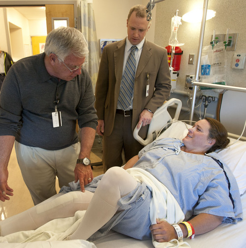 Steve Griffin  |  The Salt Lake Tribune
Chris Pelt, an orthopedist at the University of Utah, center, looks on as his patient, Julie Harris,  works with physical therapist Chuck Graybill. Getting patients up and moving on the same day of their surgery speeds recovery and cuts health costs