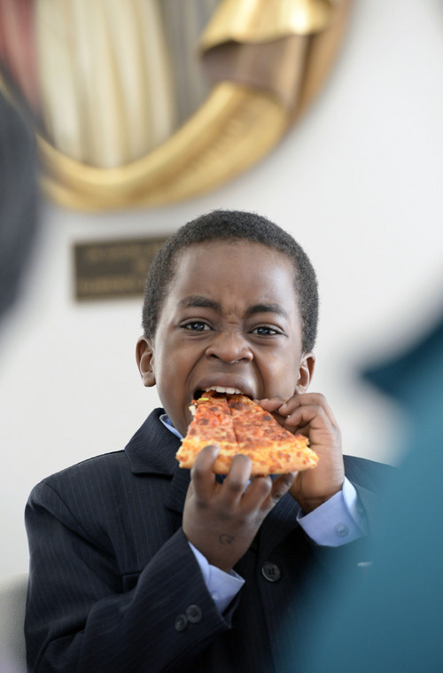 Al Hartmann  |  The Salt Lake Tribune
Desire Ramazan, a refugee from Burundi, bites into a slice of pizza at the Refugee Christmas Party sponsored by Catholic Community Services of Utah at St. Vincent de Paul Parish Sunday Dec. 8, 2013. He and his mother and five brothers and sisters lived for five years in a Malawi refugee camp before making it to Utah seven months ago. Each year, Utah receives approximately 1,200 refugees from all around the world. And each year, Catholic Community Services of Utah (CCS) helps to welcome them with this party.