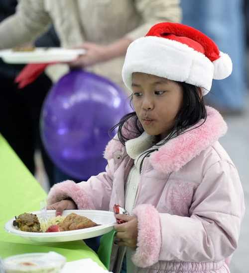 Al Hartmann   |   The Salt Lake Tribune
Ringding Latin, a refugee from Myanmar, ponders all the different kinds of food on the buffet line at the Refugee Christmas Party sponsored by Catholic Community Services of Utah at St. Vincent de Paul Parish on Sunday Dec. 8, 2013. She and her parents and two other siblings came from Myanmar about a year ago. Her father has found work, her mother is learning English and she and her brother and sister are attending school.  Each year, Utah receives approximately 1,200 refugees from all around the world. And each year, Catholic Community Services of Utah (CCS) helps to welcome them with this party.