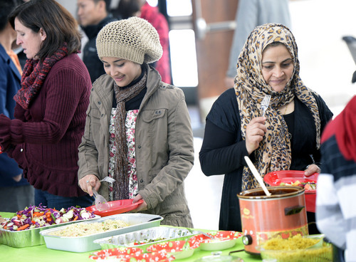 Al Hartmann  |  The Salt Lake Tribune
Sarah Achir, left, and her mother, Kaldya Al Dif,e enjoy a feast of traditional and American food at the Refugee Christmas Party sponsored by Catholic Community Services of Utah at St. Vincent de Paul Parish Sunday Dec. 8, 2013. They arrived from Iraq six months ago. Each year, Utah receives approximately 1,200 refugees from all around the world. And each year, Catholic Community Services of Utah (CCS) helps to welcome them with this party.