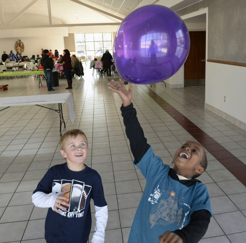 Al Hartmann  |  The Salt Lake Tribune
Ian McIntire, 6, and his new friend Zugman Fiidow, 6, bat a ballon around at the Refugee Christmas Party sponsored by Catholic Community Services of Utah at St. Vincent de Paul Parish Sunday Dec. 8, 2013. Fiidow is a recently arrived refugee from Somalia. Each year, Utah receives approximately 1,200 refugees from all around the world. And each year, Catholic Community Services of Utah (CCS) helps to welcome them with this party.