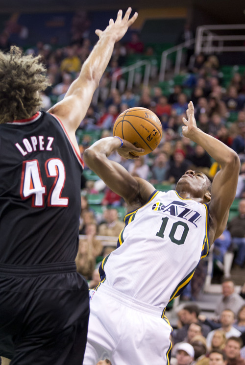 Lennie Mahler  |  The Salt Lake Tribune
Utah Jazz guard Alec Burks scores on a circus shot over Robin Lobez in the first half of a game against the Portland Trailblazers on Monday, Dec. 9, 2013.