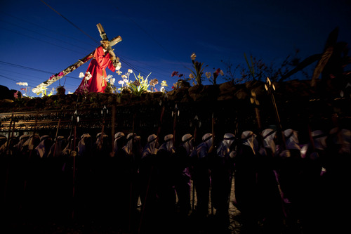 La Merced Catholic church penitents carry a statue of Jesus Christ in a morning procession through the streets of Antigua Guatemala, Guatemala, Friday, March 29, 2013.  (AP Photo/Moises Castillo)