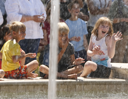 Leah Hogsten  |  The Salt Lake Tribune
l-r Troupe Wagstaff, 3, brother Finn Wagstaff, 7, and their cousin Elesa Wiser, 7, enjoy getting sprayed by the fountain during the dedication Friday, June 15, 2012 in Farmington.  The Station Park shopping center in Farmington unveiled a world-class show fountain with choreographed lights, music, color and 30-60-foot high dancing water.
