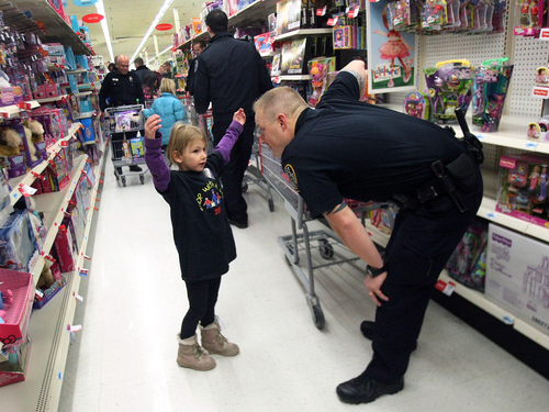 Scott Sommerdorf   |  The Salt Lake Tribune
Sarah Kuddes tells Draper officer Josh Harris during the "Shop With a Cop" event that she is looking for a toy in "a big box" as they shop at the K-Mart in West Jordan, Saturday December 13 2013.