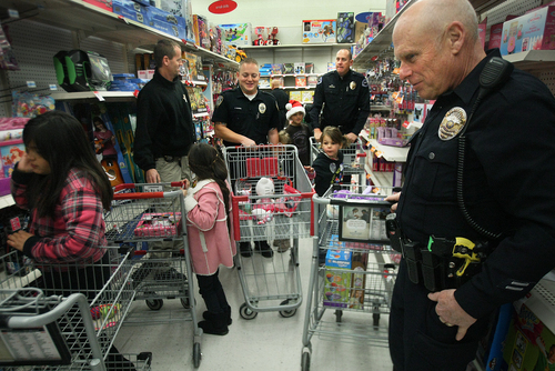 Scott Sommerdorf   |  The Salt Lake Tribune
Police officers from various agengies fill the aisles at the K-Mart in West Jordan as they shop for their assigned kids during the "Shop With a Cop" event, Saturday December 13 2013.
