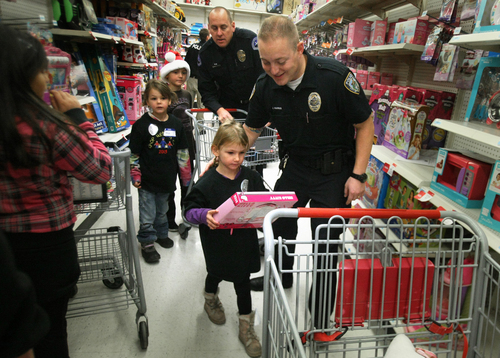 Scott Sommerdorf   |  The Salt Lake Tribune
Sarah Kuddes takes a toy to her cart as she shops with Draper officer Josh Harris as they look for things for her during the "Shop With a Cop" event at the K-Mart in West Jordan on Saturday.