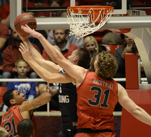 Rick Egan  | The Salt Lake Tribune 

Brigham Young Cougars guard Kyle Collinsworth (5) is fouled by Utah Utes center Dallin Bachynski (31) in basketball action, at the Huntsman Center, Saturday, December 14, 2013.