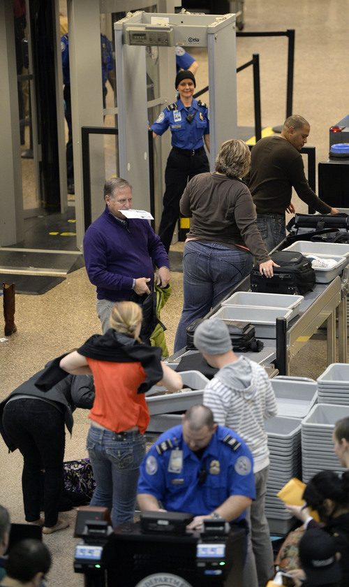 Al Hartmann  |  The Salt Lake Tribune
TSA worker checks identification and boarding passes before passengers have to remove jackets, belts, shoes, open laptops before going through the security scanners at Salt Lake International Airport Monday December 16. The airport's new PreCheck system allows travelers to skip most of these requirements speeding up the security and boarding process.