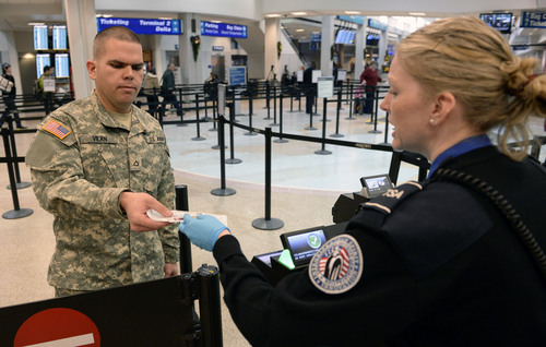 AAl Hartmann  |  The Salt Lake Tribune
TSA agent Cindy Briggs scans US Army Carlos Vilan's PreCheck boarding pass that allows him to skip having to remove belts, shoes, and light coats and opening laptops to speed up the security screening process.