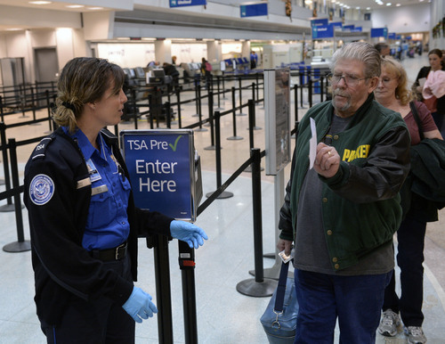 Al Hartmann  |  The Salt Lake Tribune
TSA agent Mary Jo Webb directs passengers to regular security line or through the airport's new PreCheck system allows travelers to skip having to remove belts, shoes, and light coats before going though the security screening process.