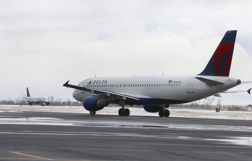 A Delta plane takes-off as another taxies after landing at the Provo Airport on December 19, 2013 in Provo, Utah. Several Delta flight were diverted and landed at the Provo Airport after the Salt Lake City a Airport was closed standing several hundred passengers.  (Photo by George Frey  |  Special to the Tribune)