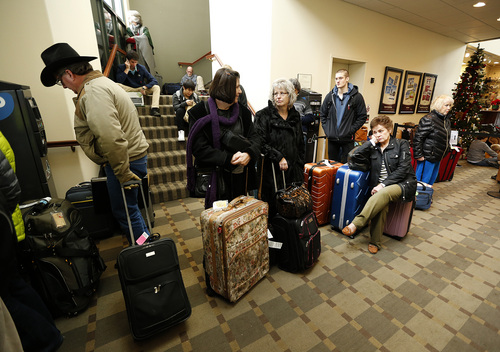 Passengers stand and sit on the floor at the Tac Air terminal after their flights were diverted to Provo at the Provo Airport on December 19, 2013 in Provo, Utah. Several Delta flight were diverted and landed at the Provo Airport after the Salt Lake City a Airport was closed standing several hundred passengers.  (Photo by George Frey  |  Special to the Tribune)