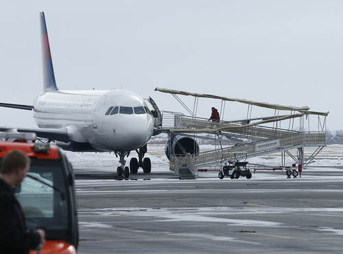 A Provo airport officials boards a Delta plane as it sits on the background at the Provo Airport on December 19, 2013 in Provo, Utah. Several Delta flight were diverted and landed at the Provo Airport after the Salt Lake City a Airport was closed standing several hundred passengers.  (Photo by George Frey  |  Special to the Tribune)