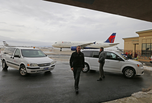 Pilots walk into the terminal as a Delta plane sit on the ground at the Provo Airport on December 19, 2013 in Provo, Utah. Several Delta flight were diverted and landed at the Provo Airport after the Salt Lake City a Airport was closed standing several hundred passengers.  (Photo by George Frey  |  Special to the Tribune)