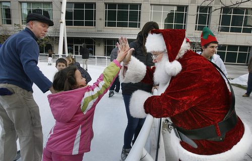 Scott Sommerdorf   |  The Salt Lake Tribune
Santa gets a high five from a young girl as she skates at the Gallivan Center skating rink, Friday November 29, 2013.