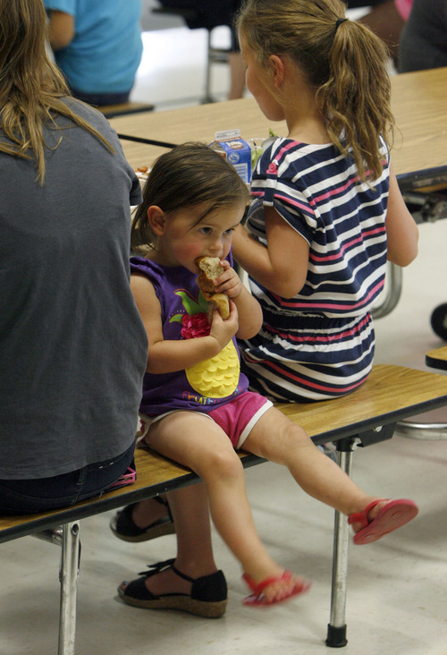 Francisco Kjolseth  |  The Salt Lake Tribune
Abby Riley, 2, chomps on a bread roll as she participates in the school lunch program at Timpanogos Elementary School in Provo on Thursday, July 11, 2013 where they regularly serve up to 250 kids under the age of 18.
