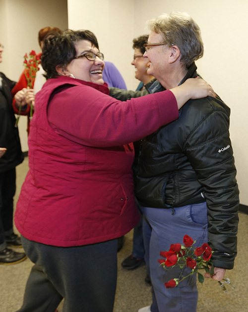 Jennifer Munson, left hands a flower to Arlene Arnold right outside the offices of the Utah County Clerk and Auditor office after Arlene received a rejection letter for a marriage license on Dec. 20, 2013 in Provo, Utah. Munson decided on her own to come down and bond out flowers after hearing the news. A federal Judge on Friday struck down Utah's ban on same sex marriage saying the law violates the U.S. Constitution.  (Photo by George Frey  |  Special to the Tribune)