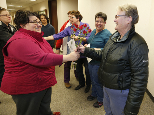 Jennifer Munson, left hands a flower to Arlene Arnold right  outside the offices of the Utah County Clerk and Auditor office after Arlene received a rejection letter for a marriage license on Dec. 20, 2013 in Provo, Utah. Munson decided on her own to come down and bond out flowers after hearing the news. A federal judge on Friday struck down Utah's ban on same sex marriage saying the law violates the U.S. Constitution.  (Photo by George Frey  |  Special to the Tribune)