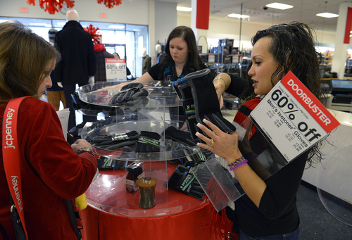 Scott Sommerdorf   |  The Salt Lake Tribune
Store manager Elizabeth Maack, left, Nikki Woodard and Shannon Guerra work to re-stock a display with sale items at the JC Penney store in the Valley Fair Mall, Saturday December 21, 2013.
