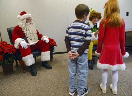 Steve Griffin  |  The Salt Lake Tribune

James Good, 6, and Shayla Brown, 7, meet Santa and his elf at VitalSmarts in Provo Friday, December 20, 2013. The founder of the Utah company, Joseph Grenny, is running an experiment with kids and Santa. Grenny, coauthor of the NY Times bestselling book "Crucial Conversations," says the study reveals that how we talk about Christmas can have a big impact on how kids approach gifts, giving and gratitude. Good and Brown were part of a control group during the experiment. Here Chase McMillan, of Vital Smarts, explains to the children their role in the experiment.