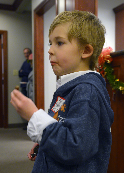Steve Griffin  |  The Salt Lake Tribune
Kayden Carter, 6, enjoys a piece of chocolate after meeting Santa and his elf at VitalSmarts in Provo on Friday. The founder of the Utah company, Joseph Grenny, is running an experiment with kids and Santa. Grenny, coauthor of the NY Times bestselling book "Crucial Conversations," says the study reveals that how we talk about Christmas can have a big impact on how kids approach gifts, giving and gratitude.