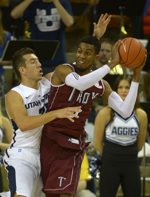 Rick Egan  | The Salt Lake Tribune 

Utah State Aggies guard/forward Spencer Butterfield (21) puts pressure on Troy Trojans forward/center Westley Hinton (33), in the final game of the Basketball Travelers Classic Tournament, at the Dee Glen Smith Spectrum, in Logan, Friday, December 20, 2013.