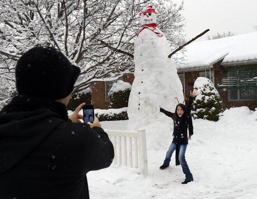 Scott Sommerdorf   |  The Salt Lake Tribune
As snow continued to fall, Mark Thomas stopped to make a photo of his daughter, Elektra, next to an impressively large snowman that was close to twelve feet tall in the front of a yard on 2300 East near 3300 South, Sunday December 22, 2013.
