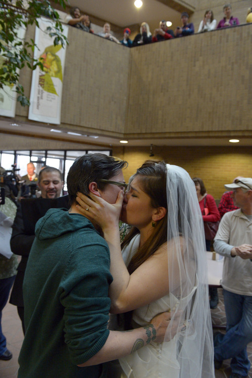Francisco Kjolseth  |  The Salt Lake Tribune
Jax Collins, left, and Heather Collins embrace in a kiss after being married by Rev. Christopher Scuderi of Universal Heart Ministry on Monday, Dec. 23, 2013, at the Salt Lake City County offices. Hundreds of same-sex couples descended on county clerk offices around the state of Utah to request marriage licenses. A federal judge in Utah struck down the state's ban on same-sex marriage last Friday, saying the law violates the U.S. Constitution's guarantees of equal protection and due process.
