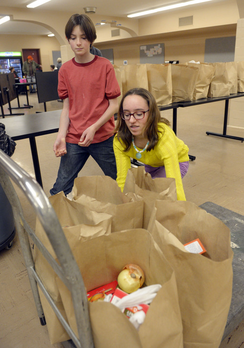 Steve Griffin  |  The Salt Lake Tribune


Rowland Hall seventh graders Noah Blumenthal and Annika Pollapsek organize bags of groceries during the annual Christmas Food Giveaway sponsored by Crossroads Urban Center at Rowland Hall School in Salt Lake City, Utah Monday, December 23, 2013. The food giveaway has been going on for decades and it is the 19th year it has been hosted by Rowland Hall. About 1,000 families received food for a Christmas dinner during the day long event.