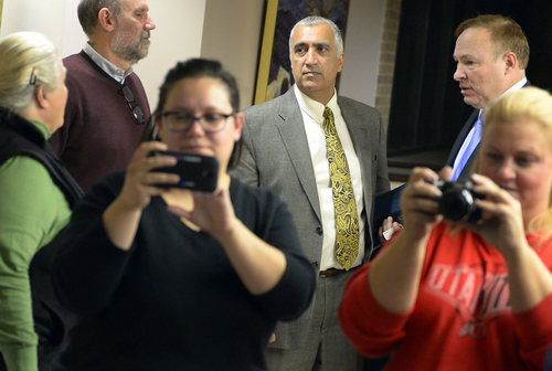 Keith Johnson | The Salt Lake Tribune

Salt Lake County District Attorney Sim Gill, center talkes to Utah Sen. Jim Dabakis, right, outside the Salt Lake County clerks office Friday, December 20, 2013 as a same sex couple gets married in the foreground. Sen. Dabakis  was trying to keep the clerks office open late Friday to accommodate same sex couples seeking marriage licenses. Dabakis married his parnter earlier that afternoon at the county office. A federal judge in Utah Friday struck down the state's ban on same-sex marriage, saying the law violates the U.S. Constitution's guarantees of equal protection and due process.