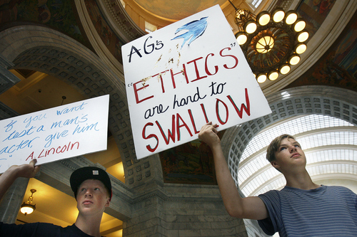 Scott Sommerdorf   |  The Salt Lake Tribune

Jaden Fry, left and River Hale, hold up signs at a rally in the Capitol Rotunda in a show of solidarity to protest alleged corruption in the attorney general's office as House Republicans meet to discuss possible impeachment proceedings against John Swallow, Wednesday, June 19, 2013.