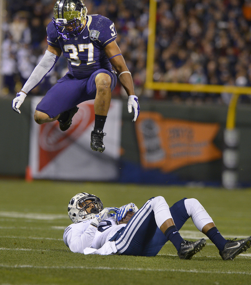 Scott Sommerdorf   |  The Salt Lake Tribune
Washington Huskies linebacker Princeton Fuimaono (37) leaps over Brigham Young Cougars wide receiver Cody Hoffman (2) during first half play at the Fight Hunger Bowl at AT&T Park in San Francisco, Friday December 27, 2013.