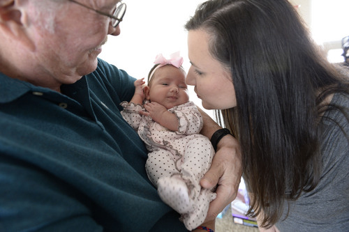 Francisco Kjolseth  |  The Salt Lake Tribune
John Whiteaker holds his granddaughter Paige, 7 weeks, as  daughter-in-law Robin Brown sneaks a kiss to her daughter during a visit to their home in Centerville on Sunday, Dec. 29, 2013. Hundreds of same-sex couples have wed since a federal judge struck down Utah's gay marriage ban Dec. 20. For many of the newlyweds' parents, it's a milestone they never thought they'd see their children reach.