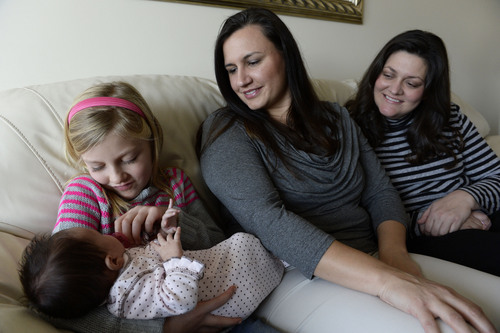 Francisco Kjolseth  |  The Salt Lake Tribune
McCall Whiteaker, 8, holds her sister Paige, 7 weeks, as she joins her two moms, Robin Brown, center, and Amber Whiteaker, in Centerville on Sunday, Dec. 29, 2013. Hundreds of same-sex couples have wed since a federal judge struck down Utah's gay marriage ban. For many of the newlyweds' parents, it's a milestone they never thought they'd see their children reach.