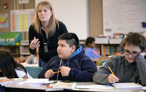 Al Hartmann  |  The Salt Lake Tribune
Bennion Elementary School fifth-grade teacher Lynette Miller helps students in a critical thinking and writing problem for the quote of the day.  She works in the Advancement Via Individual Determination (AVID) program at the school. The program is designed to get students thinking at an early age of completing a degree at a four-year college.