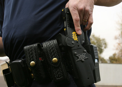 Photo by Leah Hogsten  |  The Salt Lake Tribune
Above, Richfield Police officer Shane Scott demonstrates the use of the police squads Taser X26 guns. The tasers have been used 11 times since 2005 and has eliminated the chance of officer injury during altercations with suspects during arrests. 
 10/30/09 Richfield
