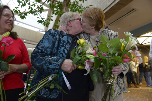 Francisco Kjolseth  |  The Salt Lake Tribune
Coral Mangus, 63, center, and her partner of 25-years Andrea Dahl, 56, are married in the lobby of the Salt Lake County offices by Reverend Patty Willis on Monday, Dec. 23, 2013. Mangus and Dahl joined hundreds of other same-sex couples at the Salt Lake County offices to request marriage licenses. Numerous officiants were on hand to perform the wedding ceremonies right after. A federal judge in Utah struck down the state's ban on same-sex marriage last Friday, saying the law violates the U.S. Constitution's guarantees of equal protection and due process.