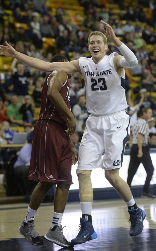 Rick Egan  | The Salt Lake Tribune 

Utah State Aggies forward Kyle Davis (23) celebrates after giving the Aggies a huge lead in the first half with a slam dunk, in basketball action, Utah State vs.Troy, at the Dee Glen Smith Spectrum, in Logan, Friday, December 20, 2013.