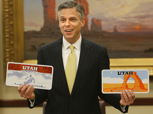 Gov Jon Huntsman holds the two new license plate designs  featuring the  motto,"Life Elevated". He signed a bill today authorizing the new plates. photo: paul fraughton/Salt Lake Tribune 3/13/07