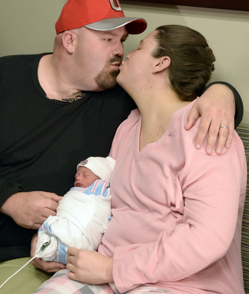 Al Hartmann  |  The Salt Lake Tribune
John Schuler and his wife Whitney Buckley share a kiss holding their new baby Anthony John Schuler who was born at Jordan Valley Medical Center  in West Jordan three seconds after midnight January 1 2014.   He was born five weeks premature weighing only 4 lbs. 3 oz. but he is healthy and doing well.