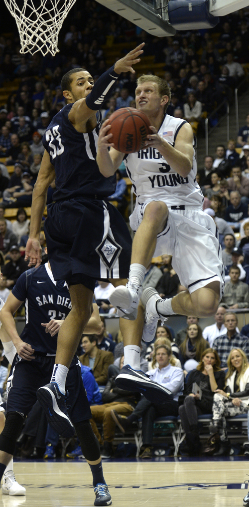 Rick Egan  | The Salt Lake Tribune 

Brigham Young Cougars guard Tyler Haws (3) takes the ball under the hoop, as San Diego forward/center Jito Kok (33), as he goes up for a shot,  in basketball action, BYU vs. The San Diego Toreros at the Marriott Center,  Saturday, January 4, 2014.