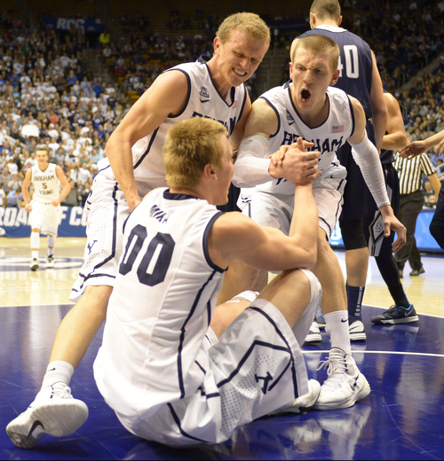 Rick Egan  | The Salt Lake Tribune 

Brigham Young Cougars guard Tyler Haws (3) and Brigham Young Cougars guard Skyler Halford (23) give Eric Mika (00) a helping hand up after Mika scored on a big slam dunk,  in basketball action, BYU vs. The San Diego Toreros at the Marriott Center,  Saturday, January 4, 2014.